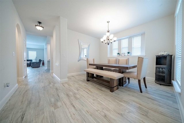 4130 Lagoon Pl, Royse City, TX 75189 - dining room featuring arched walkways, light wood-style flooring, a chandelier, and baseboards