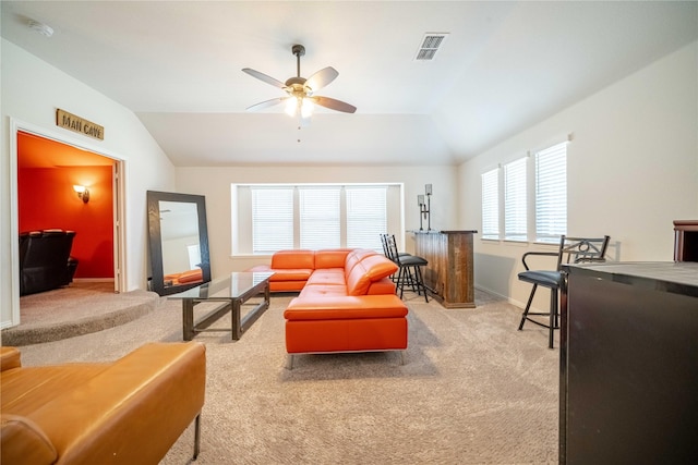 carpeted living area with baseboards, visible vents, a ceiling fan, and lofted ceiling