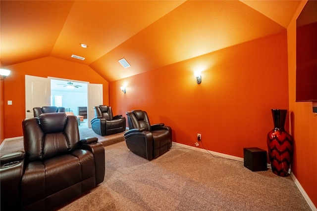 carpeted home theater room featuring visible vents, lofted ceiling, and baseboards