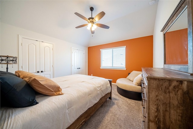 bedroom with multiple closets, carpet floors, baseboards, ceiling fan, and vaulted ceiling