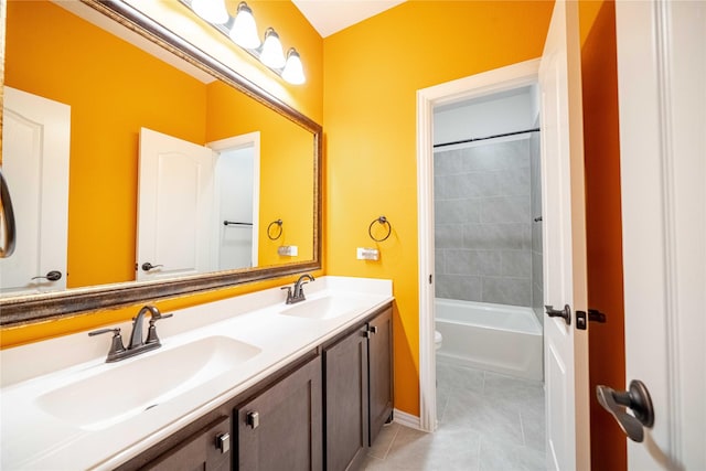 full bathroom with a sink, toilet, double vanity, and tile patterned flooring