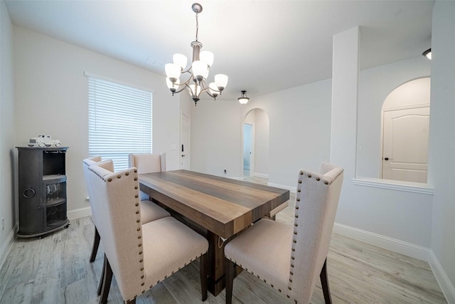 4130 Lagoon Pl, Royse City, TX 75189 - dining area with arched walkways, a chandelier, and light wood-style flooring