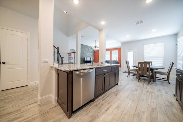 kitchen featuring light wood finished floors, dark brown cabinets, light stone countertops, and stainless steel dishwasher