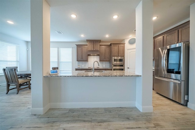 4130 Lagoon Pl, Royse City, TX 75189 - kitchen featuring appliances with stainless steel finishes, light stone counters, light wood-style flooring, and recessed lighting