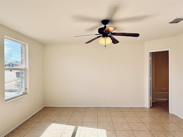 empty room with ceiling fan, visible vents, baseboards, and light tile patterned flooring