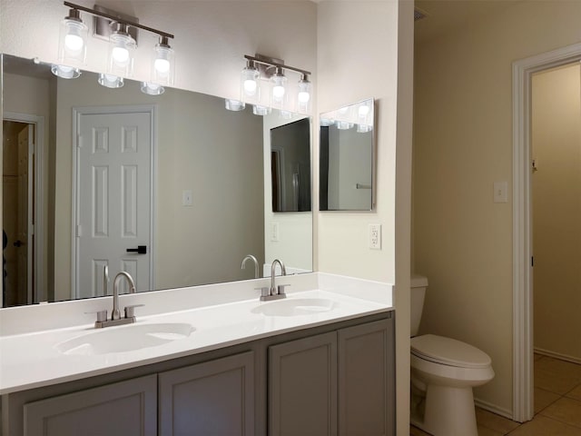 full bathroom with toilet, tile patterned flooring, double vanity, and a sink