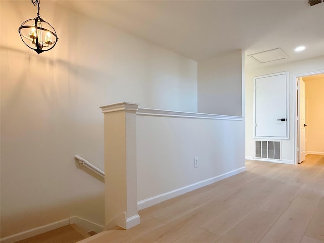 corridor with visible vents, baseboards, light wood-style flooring, an upstairs landing, and recessed lighting