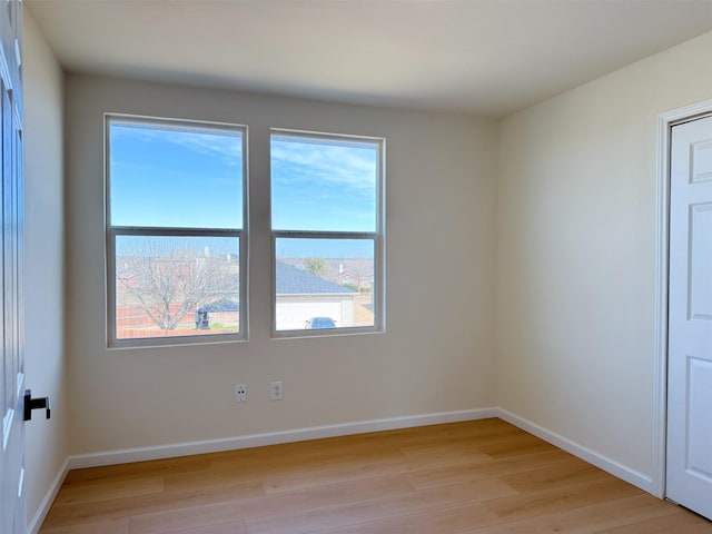 unfurnished room featuring light wood-style flooring and baseboards