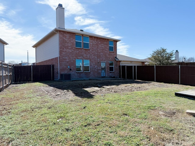 back of house featuring brick siding, a yard, a chimney, cooling unit, and a fenced backyard