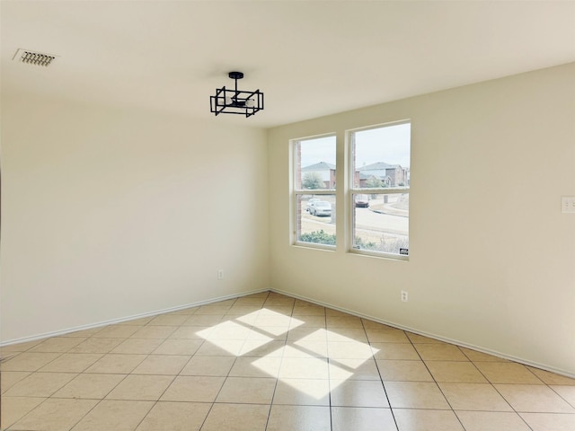 unfurnished room with visible vents, baseboards, and light tile patterned floors