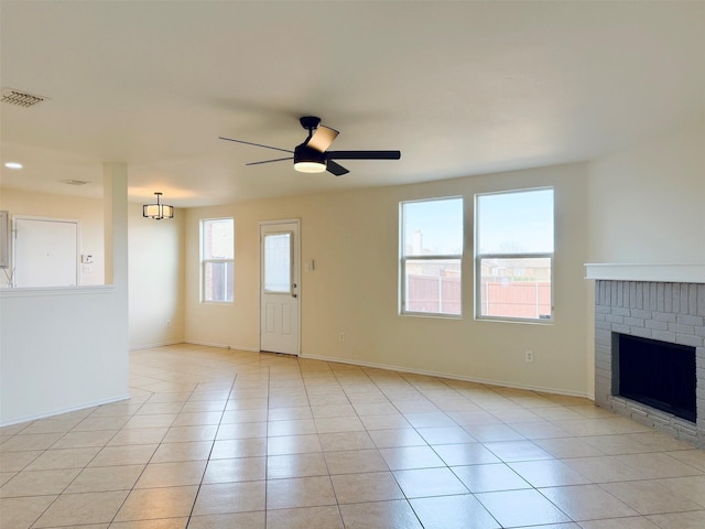 unfurnished living room featuring ceiling fan, visible vents, a fireplace, and light tile patterned flooring