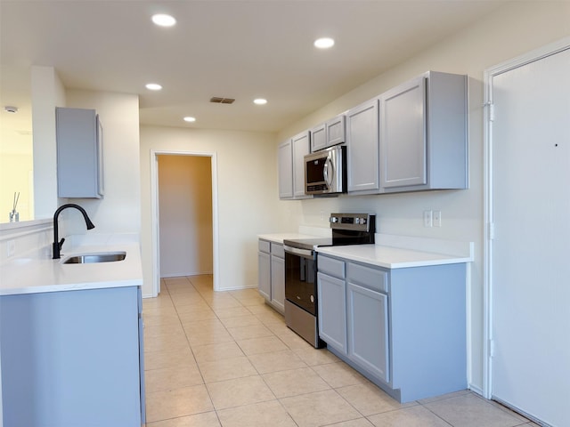 kitchen with recessed lighting, visible vents, gray cabinetry, appliances with stainless steel finishes, and a sink