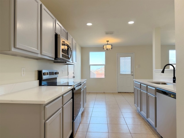 kitchen with light tile patterned floors, recessed lighting, gray cabinetry, appliances with stainless steel finishes, and a sink