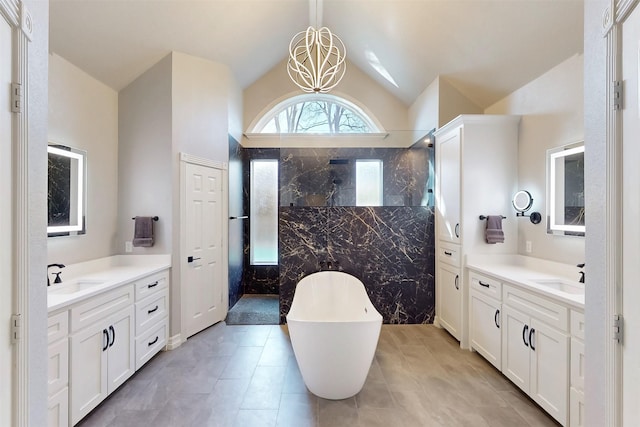 bathroom with vaulted ceiling, walk in shower, two vanities, and a sink