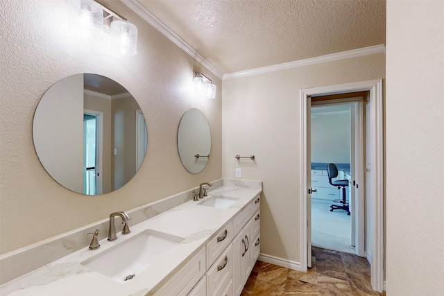 bathroom with double vanity, a textured ceiling, ornamental molding, and a sink