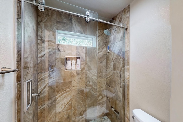 bathroom featuring a shower stall and toilet