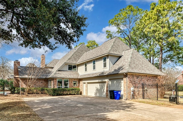 view of front of property with driveway, roof with shingles, fence, and brick siding