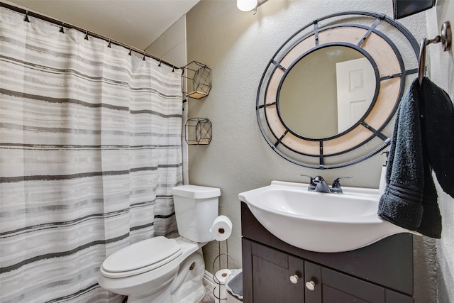 full bath with a shower with shower curtain, a textured wall, vanity, and toilet