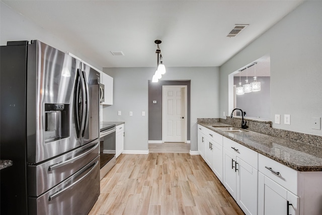 kitchen with stainless steel appliances, light wood-style floors, visible vents, and a sink