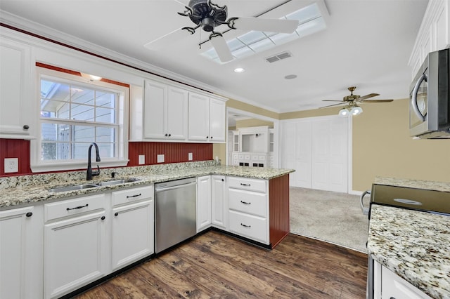 kitchen featuring visible vents, ceiling fan, a peninsula, stainless steel appliances, and a sink