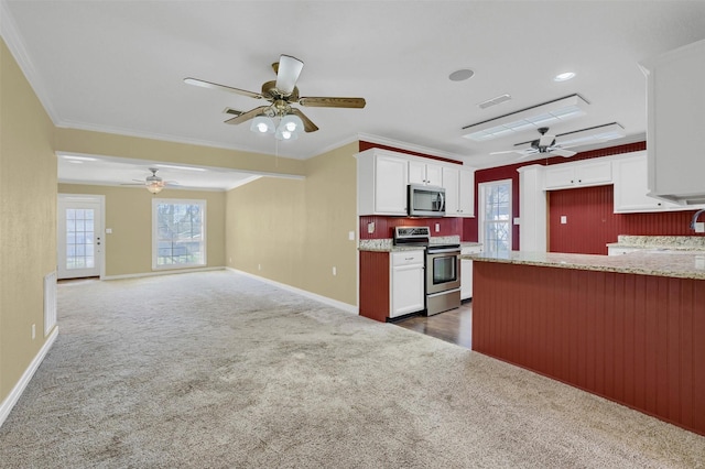 kitchen with visible vents, white cabinets, stainless steel appliances, crown molding, and carpet flooring