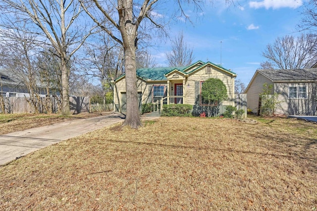 view of front of home featuring driveway, an attached garage, fence, and a front lawn