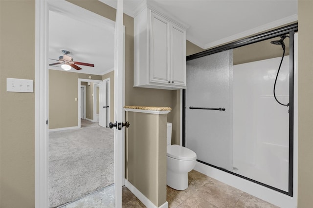 bathroom with toilet, a ceiling fan, baseboards, a stall shower, and crown molding