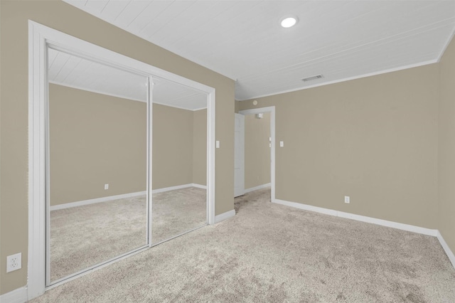 unfurnished bedroom with baseboards, a closet, visible vents, and carpet flooring