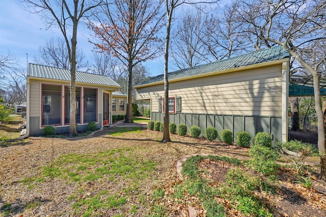 view of side of home featuring metal roof and an outdoor structure