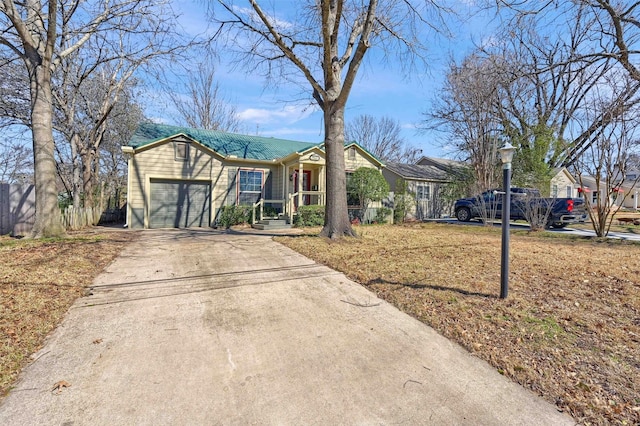 ranch-style house with driveway, a garage, and metal roof