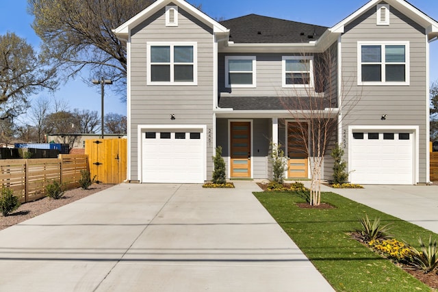 view of front of house featuring a shingled roof, concrete driveway, fence, and an attached garage