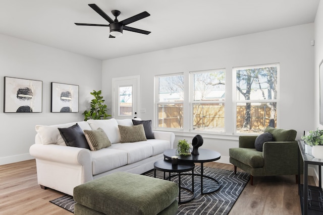 living room with ceiling fan, light wood-style flooring, and baseboards