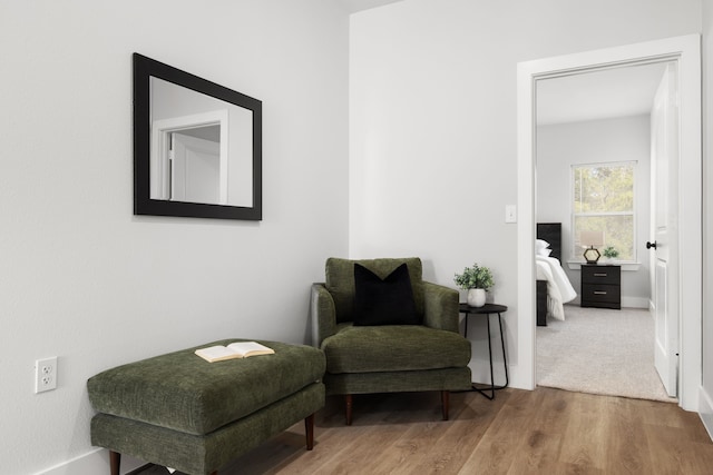 sitting room with baseboards and wood finished floors