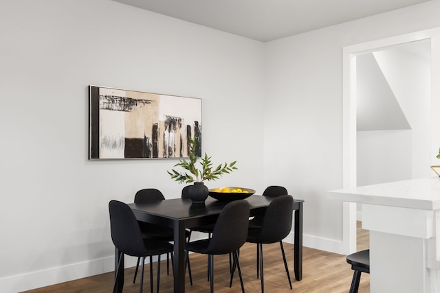 dining space with light wood-type flooring and baseboards