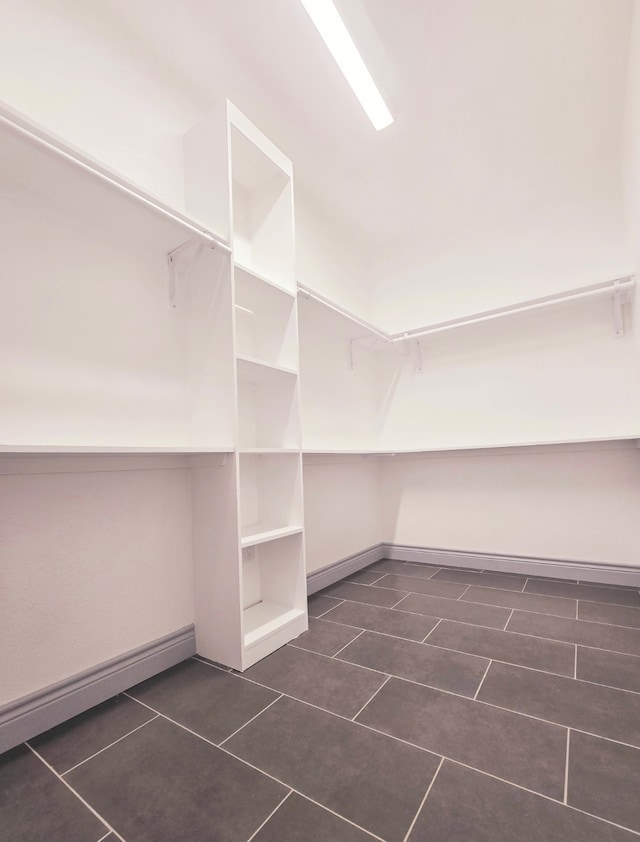 spacious closet with dark tile patterned flooring