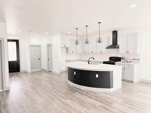 5147 Chapman St, Fort Worth, TX 76105 - kitchen with wall chimney range hood, black range oven, a sink, a kitchen island with sink, and light wood-style flooring