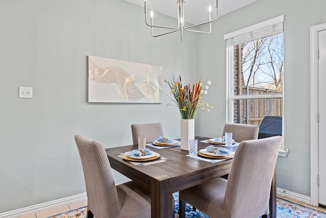 dining area featuring baseboards and a chandelier