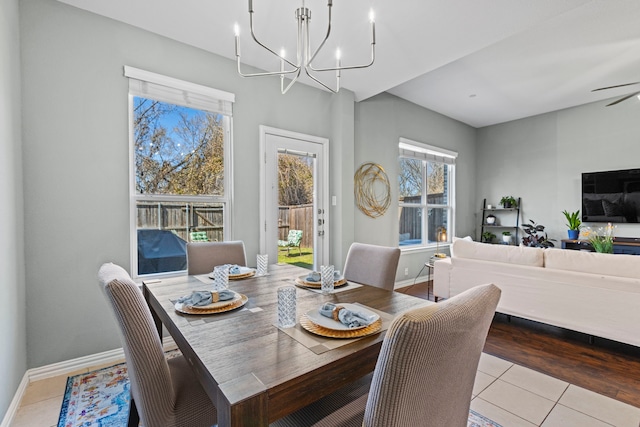 tiled dining area featuring ceiling fan with notable chandelier and baseboards