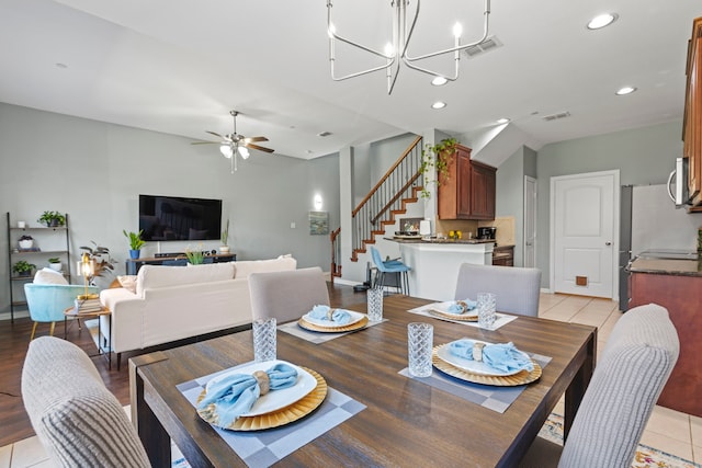 dining space featuring ceiling fan with notable chandelier, recessed lighting, visible vents, and stairs