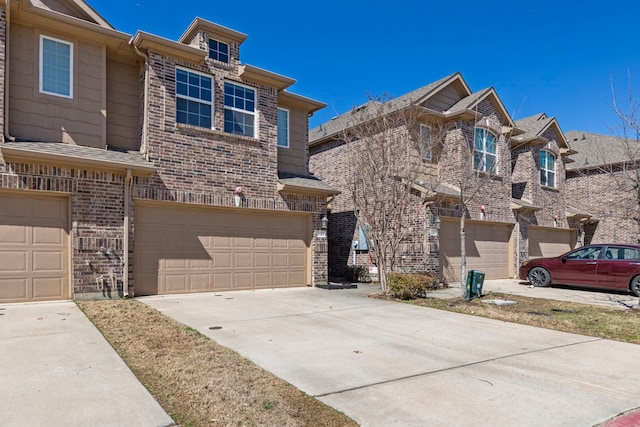 view of front facade featuring driveway, an attached garage, and brick siding