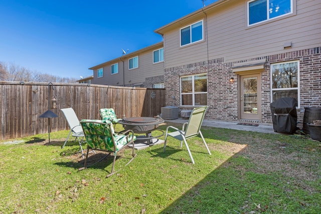 view of yard featuring cooling unit, fence, and a fire pit