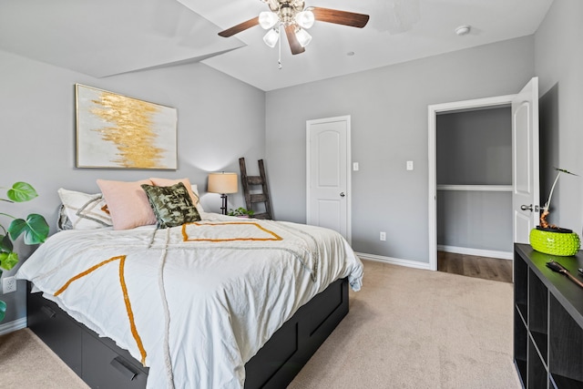 carpeted bedroom with ceiling fan and baseboards