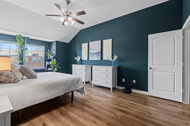 bedroom with lofted ceiling, ceiling fan, baseboards, and wood finished floors