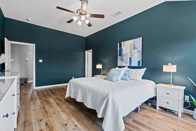 bedroom with light wood-style flooring, visible vents, ceiling fan, and baseboards