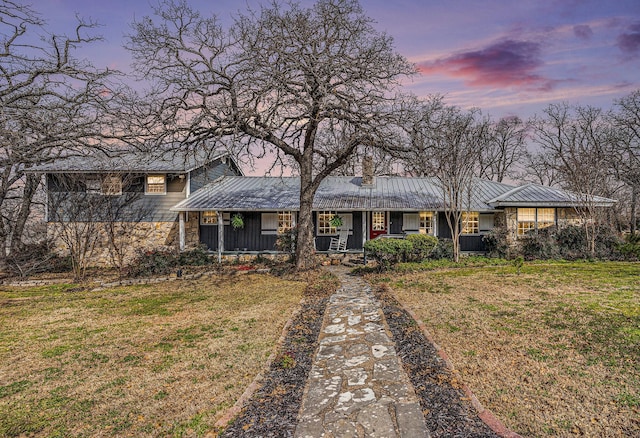 view of front of property with metal roof, a yard, and a porch