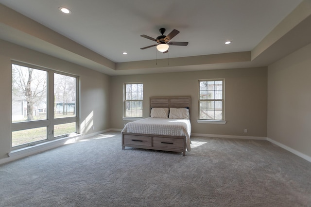 unfurnished bedroom with carpet floors, baseboards, a tray ceiling, and recessed lighting