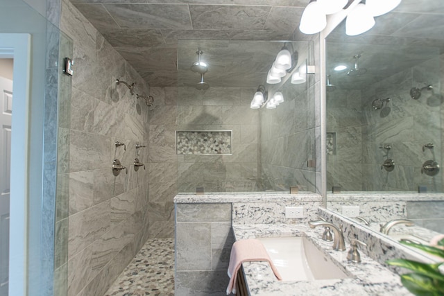 bathroom featuring a tile shower and vanity