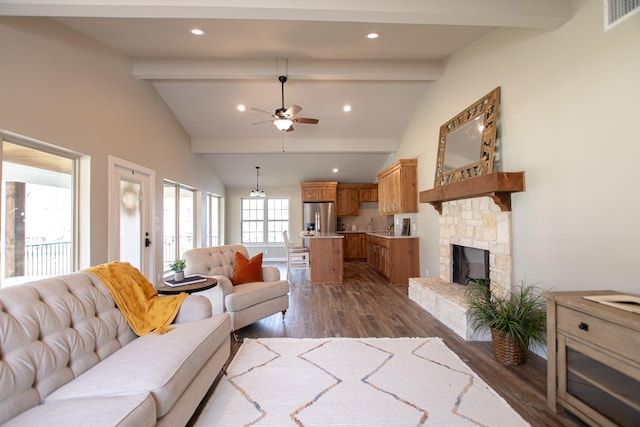 living area featuring vaulted ceiling with beams, a fireplace, visible vents, and dark wood finished floors