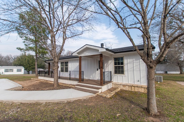 bungalow featuring a porch, a front lawn, central AC, and board and batten siding