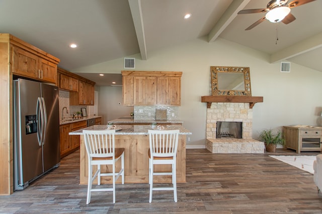 kitchen with lofted ceiling with beams, visible vents, a sink, and stainless steel fridge with ice dispenser